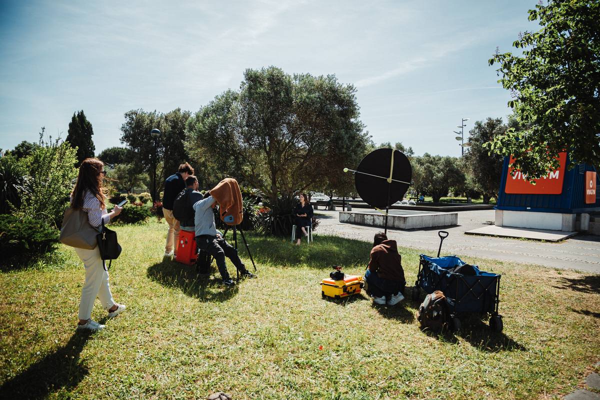 A equipa da Panorama monta o material para uma entrevista num jardim